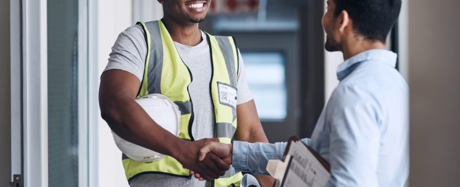 Electrician subcontractor shaking hands with a contractor for a mutual project.