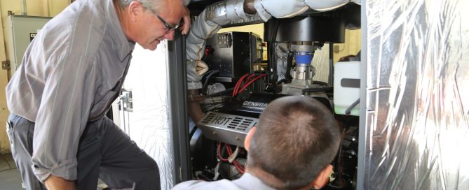 Photo of two Duthie Power professional repair service technicians doing a quality assurance check on a generator.